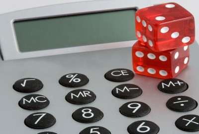 Image of desk calculator with a pair of dice on it conjuring the costs of downtime.