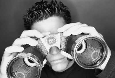 Image of man looking through binoculars depicting the need to perform a post meeting assessment
