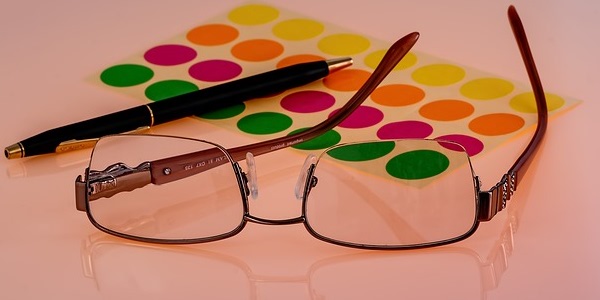 Image of eyeglasses, pen and colored tabs signifying the need for IT strategic vision.