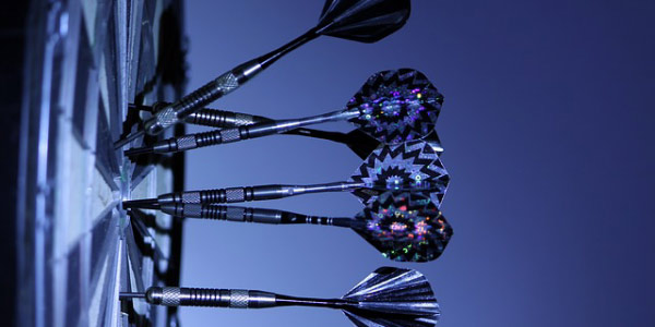 Image of darts on a dartboard representing the need to not make project assumptions.