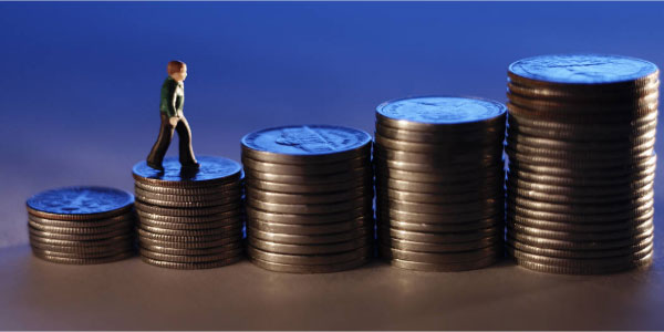 Image of business person walking up stacks of coins showing the need to create project budgets.